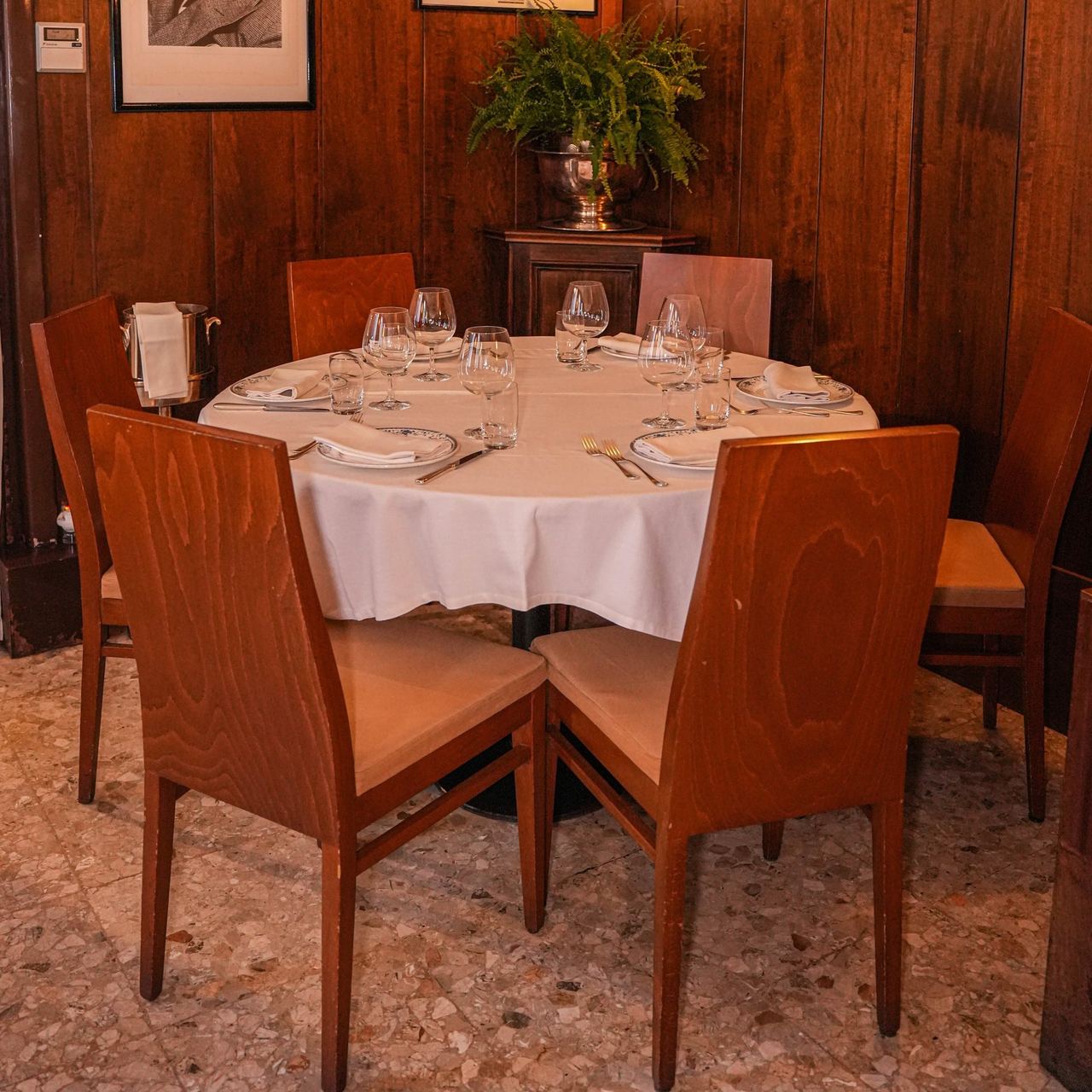 A round table set for dinner in the panelled room at Ai Gondolieri